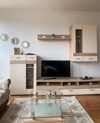 a living room with a tv and a glass table at Stan na dan Bella in Banja Luka