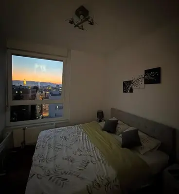 a bedroom with a bed and a large window at Stan na dan Bella in Banja Luka