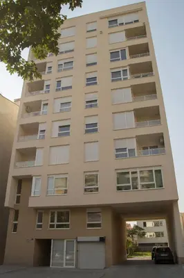 an apartment building with a parking garage at Stan na dan Bella in Banja Luka