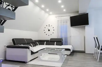 a living room with a couch and a clock on the wall at Villa Noa Kupres in Kupres