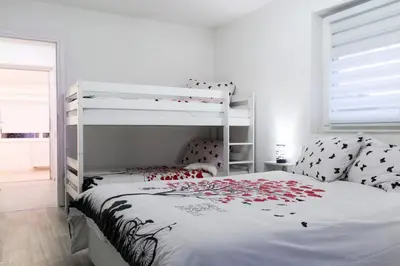 a bedroom with a white bunk bed with roses on it at Villa Noa Kupres in Kupres