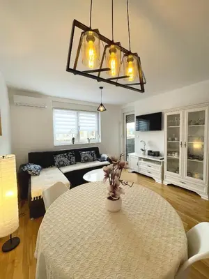 a living room with a table and a couch at Orhidea Doboj in Doboj