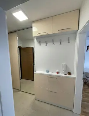 a kitchen with white cabinets and a sliding glass door at Orhidea Doboj in Doboj