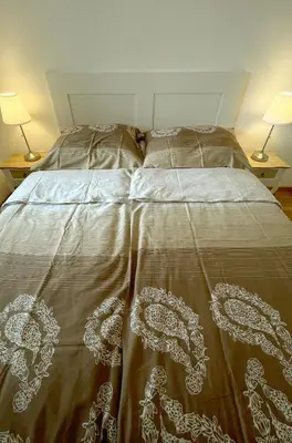 a bed in a bedroom with two lamps on two tables at Orhidea Doboj in Doboj