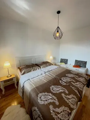a bedroom with a large bed and a lamp at Orhidea Doboj in Doboj