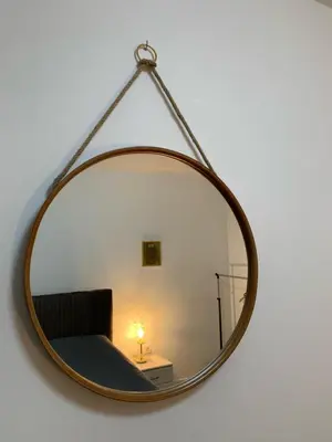 a mirror hanging on a wall with a bed in a room at VIP 2 Apartment in Visoko