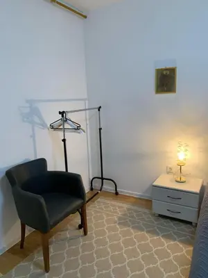 a room with a chair and a lamp and a table at VIP 2 Apartment in Visoko
