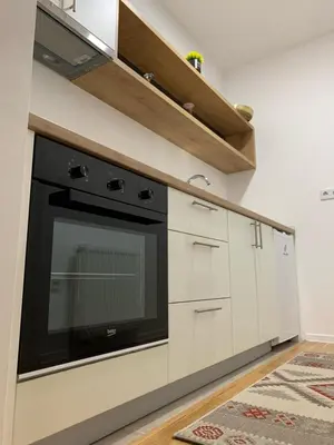a kitchen with a black oven and white cabinets at VIP 2 Apartment in Visoko