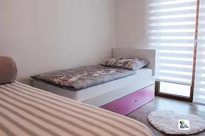 a bedroom with two beds in a room with windows at Apartman Anđela in Kupres