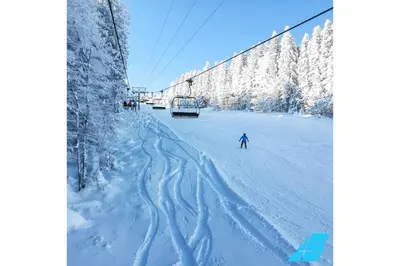 a person skiing down a snow covered slope with a ski lift at Apartman Anđela in Kupres