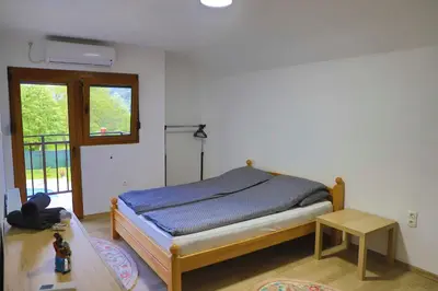 a bedroom with a bed and a table and a window at Villa Lena in Bihać