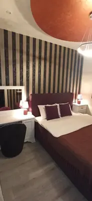 a hotel room with two beds and two tables at Apartmani President IV in Banja Luka