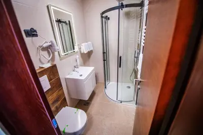 a bathroom with a shower and a toilet and a sink at Zlatna Kruna in Banja Luka