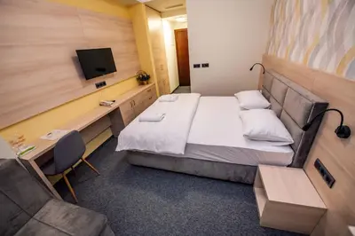 a small room with a bed and a tv at Zlatna Kruna in Banja Luka