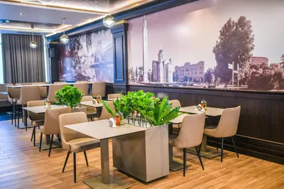 a restaurant with tables and chairs and a large wall at Zlatna Kruna in Banja Luka