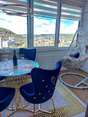 a table and chairs in a room with a window at Luxury Apartment Karic FREE parking in Tuzla