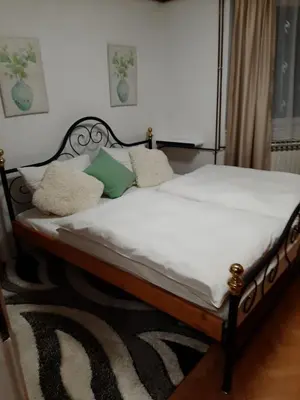 a bed with white sheets and pillows in a bedroom at Apartman Hana in Sanski most