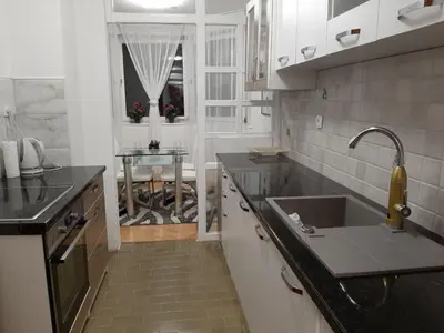 a kitchen with a sink and a table in it at Apartman Hana in Sanski most