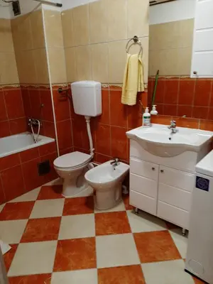 a bathroom with a toilet and a sink and a tub at Apartman Hana in Sanski most