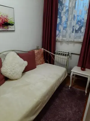 a couch in a room with red curtains at Apartman Hana in Sanski most