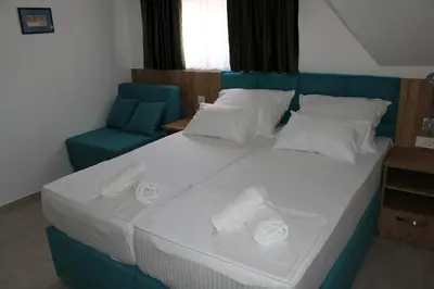 a large bed with two rolls of towels on it at Royal Apartmani in Banja Luka
