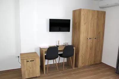 a room with a table and two chairs and a cabinet at Royal Apartmani in Banja Luka