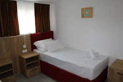 a small bedroom with a bed and a window at Royal Apartmani in Banja Luka