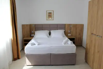 a bedroom with a large bed with white sheets at Royal Apartmani in Banja Luka