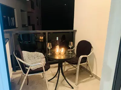 a table and two chairs with wine glasses on it at Apartman LUAN in Banja Luka