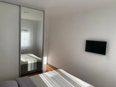 a bedroom with a mirror and a bed and a tv at Apartman LUAN in Banja Luka