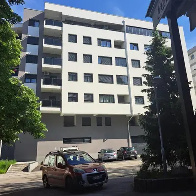 a car parked in a parking lot in front of a building at Apartman LUAN in Banja Luka