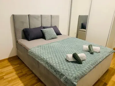 a bed with two pillows on top of it at Apartman LUAN in Banja Luka