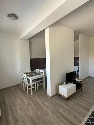 a living room with a table and a television at Apartman San in Bugojno