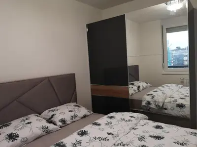 a bedroom with two beds and a mirror at Apartman Merkator in Banja Luka