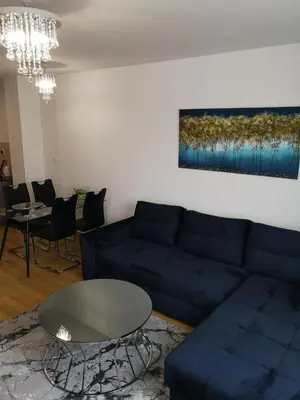 a living room with a blue couch and a table at Apartman Merkator in Banja Luka