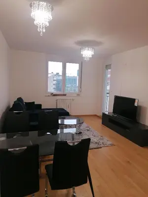a living room with a couch and a table and chairs at Apartman Merkator in Banja Luka