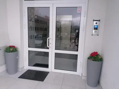 a glass door with two potted plants in front of it at Apartman Merkator in Banja Luka