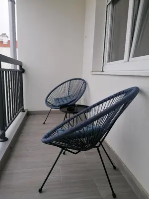 a pair of chairs sitting on a balcony at Apartman Merkator in Banja Luka