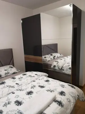 a bedroom with two beds and a mirror at Apartman Merkator in Banja Luka