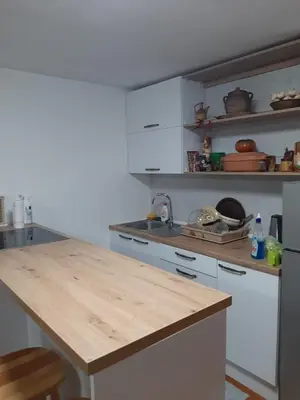 a kitchen with white cabinets and a wooden counter top at Vikendica Ajla in Travnik