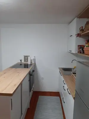 a kitchen with white cabinets and a wooden counter top at Vikendica Ajla in Travnik