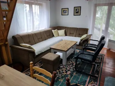 a living room with a couch and a table and chairs at Vikendica Ajla in Travnik