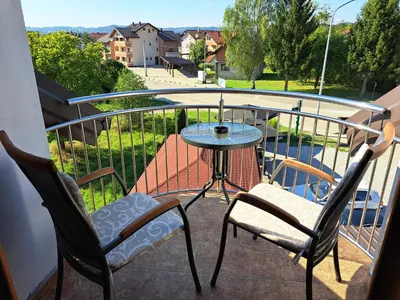 a balcony with two chairs and a table on a balcony at Apartman Bubic in Banja Vrućica
