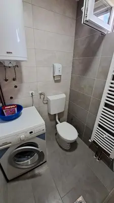 a bathroom with a toilet and a washing machine at Apartman Bubic in Banja Vrućica