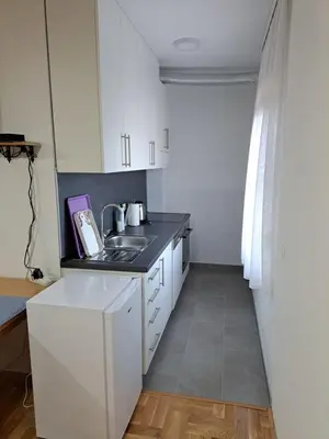 a kitchen with white cabinets and a sink at Apartman Bubic in Banja Vrućica