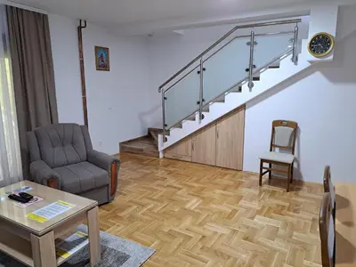 a living room with a couch and a chair and stairs at Apartman Bubic in Banja Vrućica