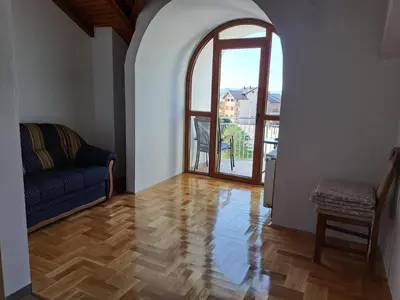 a living room with a couch and an open door at Apartman Bubic in Banja Vrućica