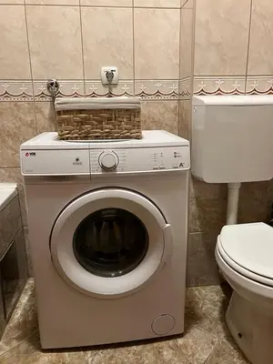 a washing machine with a basket on top of it in a bathroom at Stan na dan Centar Banja Luka in Banja Luka
