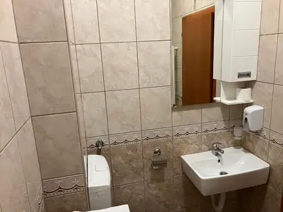 a bathroom with a sink and a toilet and a mirror at Stan na dan Centar Banja Luka in Banja Luka