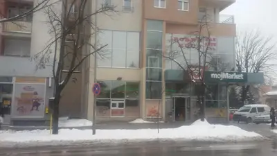 a building on a street with snow in front of it at Apartman centar blizina Kastela i Splava in Banja Luka